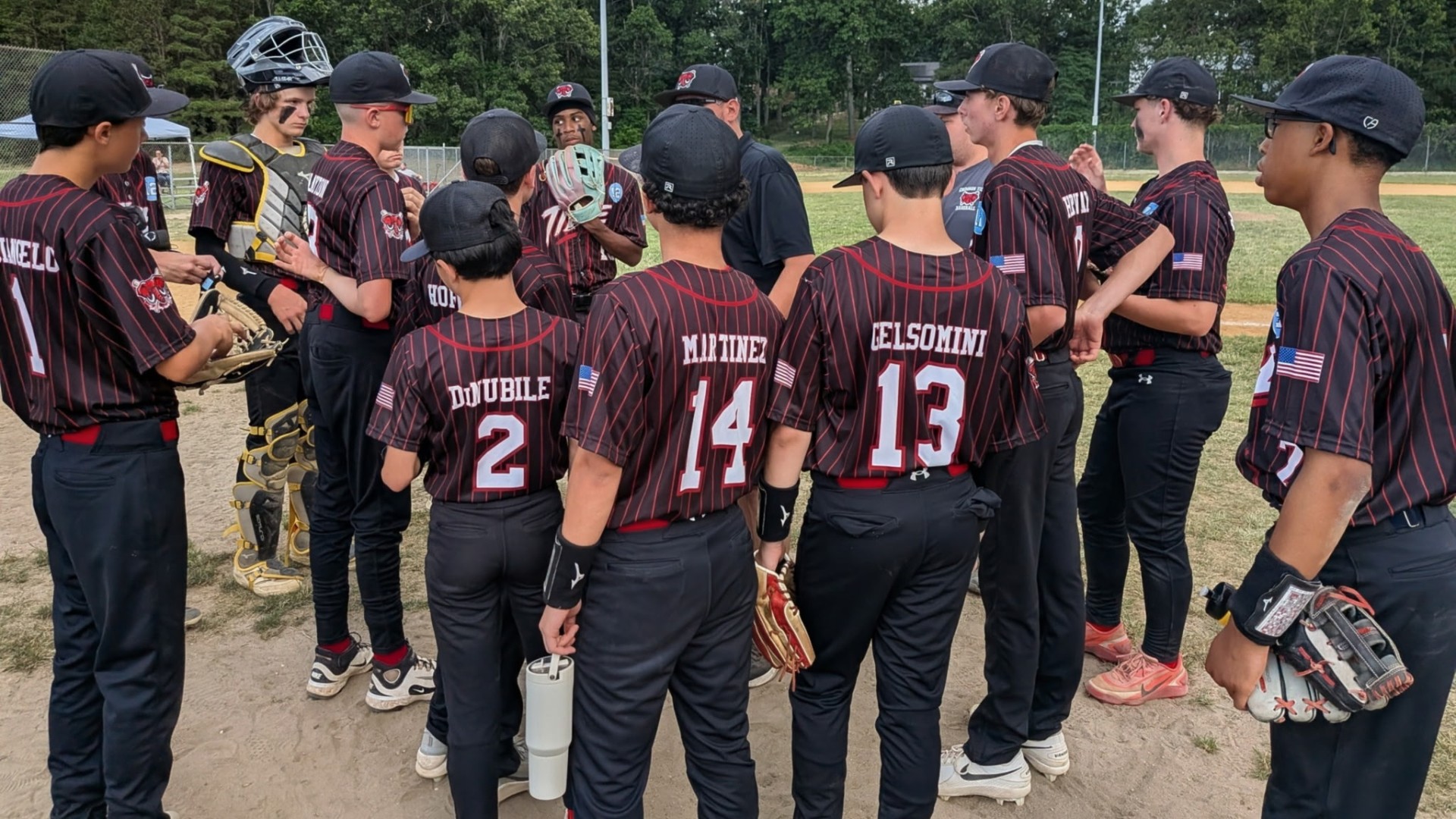 15U Crimson Tide players huddled together with coaches before the game